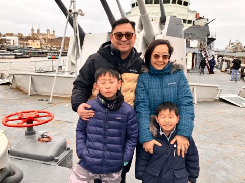 Lawrence Fong and his family stand in front of HMS Belfast