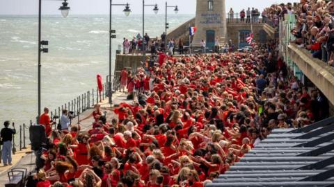 The 2023 Wuthering Heights day with people in red dresses along the harbour and others watching from above