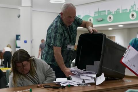 Ballot papers are poured out on to a table in front of people ready to count in Carlisle