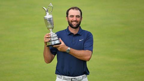 Scottie Scheffler holding the 2025 Open Championship trophy