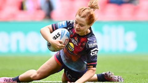 Wigan's Grace Banks touches down the ball for a try