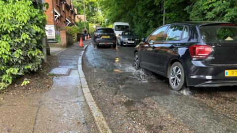 Cars driving on a flooded Grove Hill