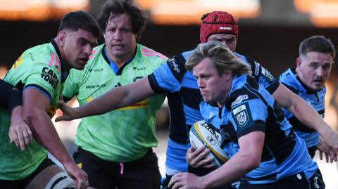 Flanker Dan Thomas runs with the ball surrounded by Cardiff team-mates and Stormers players