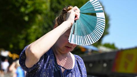 A woman holds a fan