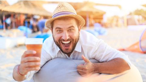 Man with beer on beach