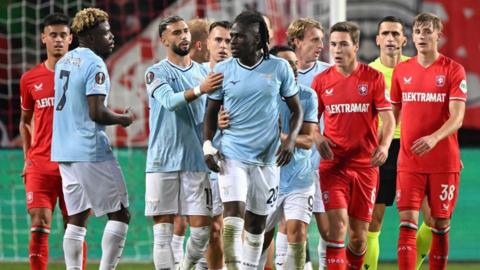 Loum Tchaouna is held by team-mates as he tries to walk away