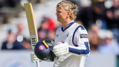 Will Luxton raises his bat after reaching a century for Yorkshire