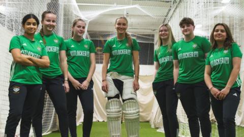 Players pose against backdrop of practice nets