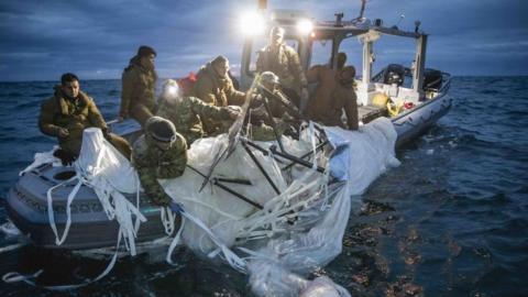 Navy personnel recovering balloon