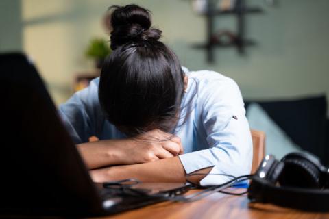 Stock photo of woman resting head on desk