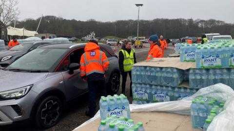 people collecting bottled water