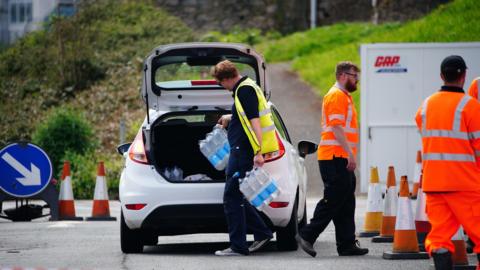 A shot of a car queuing to collect packs of bottled water at Freshwater car park in Brixham after a Boil Water Notice was issued. Households and businesses were advised not to use their tap water without boiling it first OR to use bottled water instead after traces of cryptosporidium were found in the water supply network