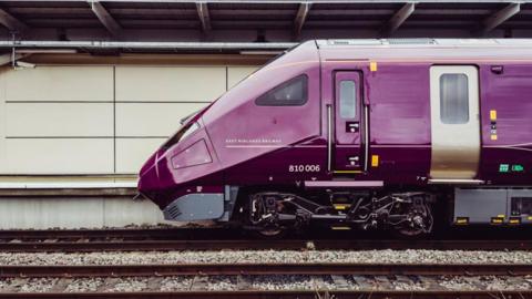 Picture of the front of a train - the class 810 - on a railway line.