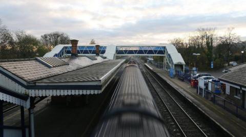 Looking down onto the tracks from above as an intercity train passes through Tilehurst Station.