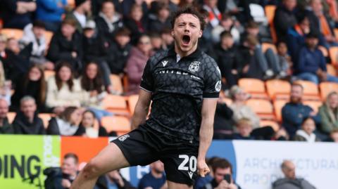 Wrexham midfielder Ollie Rathbone celebrates