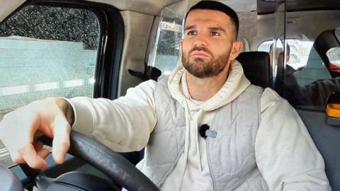 Jack Cawley behind the wheel of his black cab