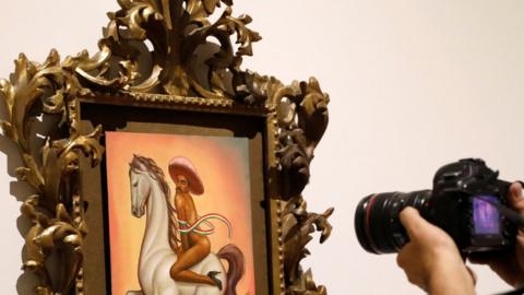 Man takes a photo of the Zapata painting