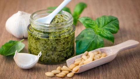 Jar of pesto with basil, pine nuts and garlic