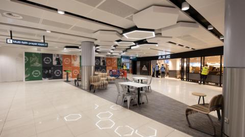 A landscape shot of part of the newly renovated Terminal 2 at Manchester Airport, including honeycomb-style lighting and a new seating area.