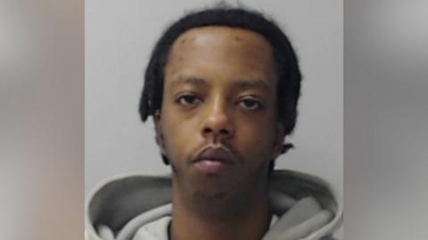 Victor Kihu looking at the camera in a police mugshot.