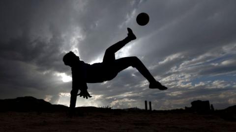 A boy plays football in a youth match in Yemen