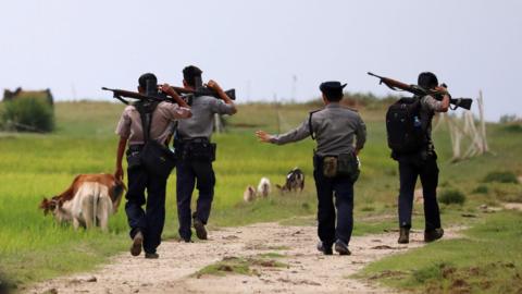 Armed Myanmar police patrol fields near Maungdaw in the northern Rakhine state in northern Myanmar