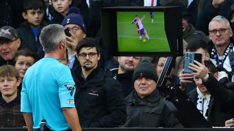 Referee checking a decision on the VAR monitor