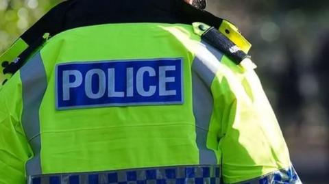 Stock picture of the back of a police officer's hi-vis jacket. No one is visable.