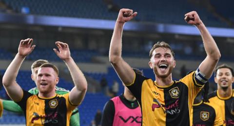 Newport County players raise arms in celebration