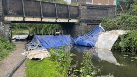 Blue and white sheeting blocking off the canal underneath a bridge in Walsall