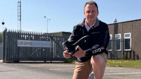 Man holding drone defensive technology in front of firm's 