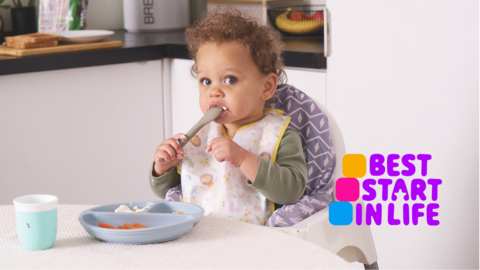 Baby with spoon in their mouth.