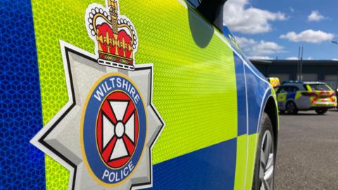 Close-up of the side of a Wiltshire Police car, showing the force logo