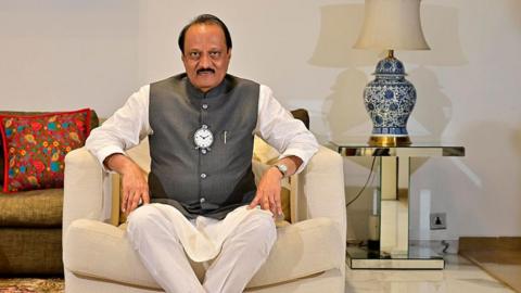 Ajit Pawar shown seated on a white chair for a photo shoot