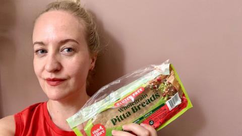 Lauren Potts holding a packet of gluten-free pitta bread