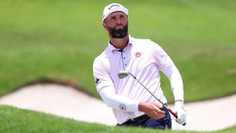Jon Rahm chips out of a bunker