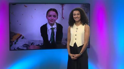 Nina in the studio with a school girl in the screen