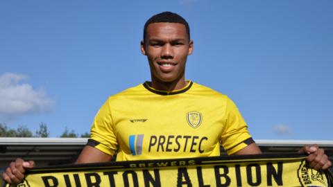 Corrie Ndaba hold a Burton Albion scarf