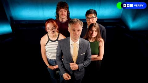 Five members of BBC Verify's team stand in a dark room.
