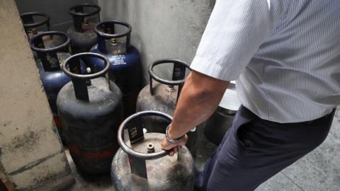 An employee - wearing shirt and trousers - checks empty commercial LPG cylinders inside Vidyarthi Bhavan restaurant in India's Bengaluru, as several restaurants and hotels in India have warned of shutdowns amid disruptions in commercial LPG supply, following the US-Israeli conflict with Iran.