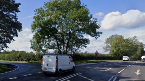 A white van drives down the A446 road. There is a junction with another road, Holly Lane, on the left.