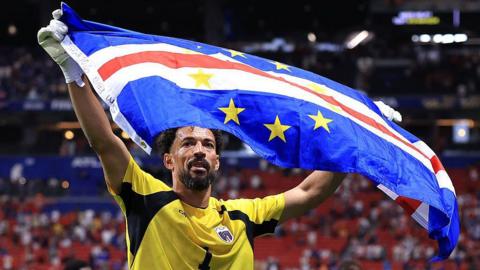 Vozinha holds a Cape Verde flag