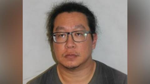 Mugshot of Vincent Chan, a man with glasses and dark hair