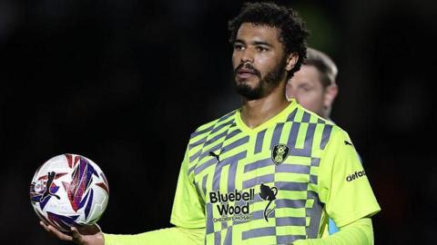 Cameron Humphreys holds the ball in his right hand as he prepares to take a throw-in during a match for Rotherham