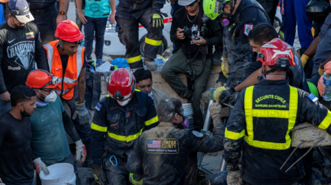 US and French rescue teams operate near a collapsed building with local volunteers