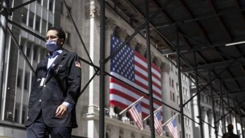 A trader walks past the New York Stock Exchange in New York, New York, USA, on 03 September 2020. The Dow Jones industrial average was down nearly 900 points today