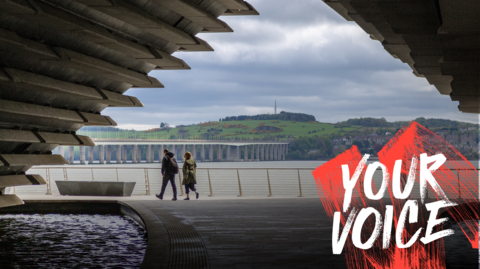 Two people walking under an archway at the V&A in Dundee. A bridge over Tay is visible in the background. 
