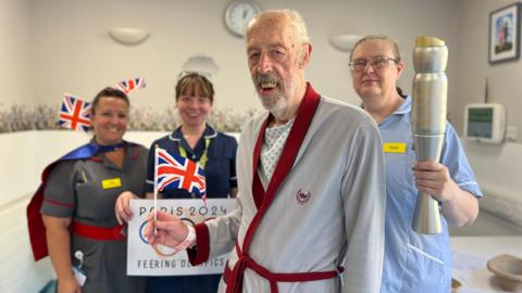 Steven Byford, who is holding a Union Jack flag, with hospital staff