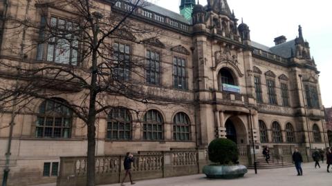 Sheffield town hall is a goth style Victorian building with large windows, a balcony and ornate stone decoration