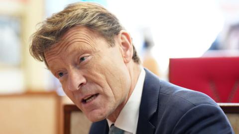 Reform deputy leader Richard Tice wearing a blue blazer, a white shirt and a pale blue tie